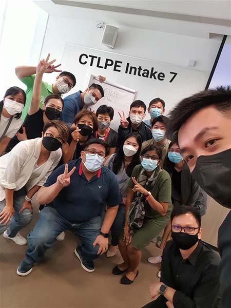 Group selfie of masked CTLPE Intake 7 participants smiling and posing for a photo.