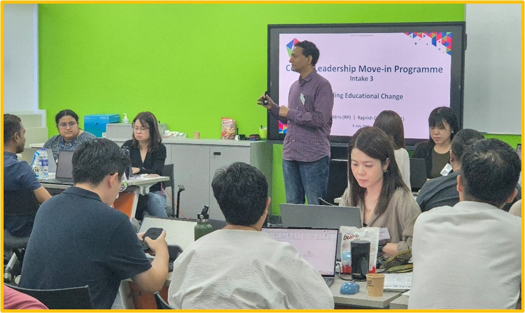 man standing infront of screen presenting.